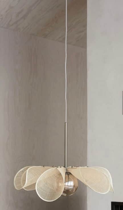 A contemporary pendant light featuring a shade composed of multiple off-white, petal-shaped fabric e… — 3D model