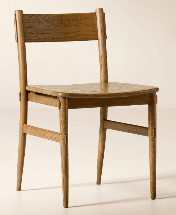 A wooden chair with a gently curved seat and a slatted backrest. The chair has four tapered legs and… — 3D model