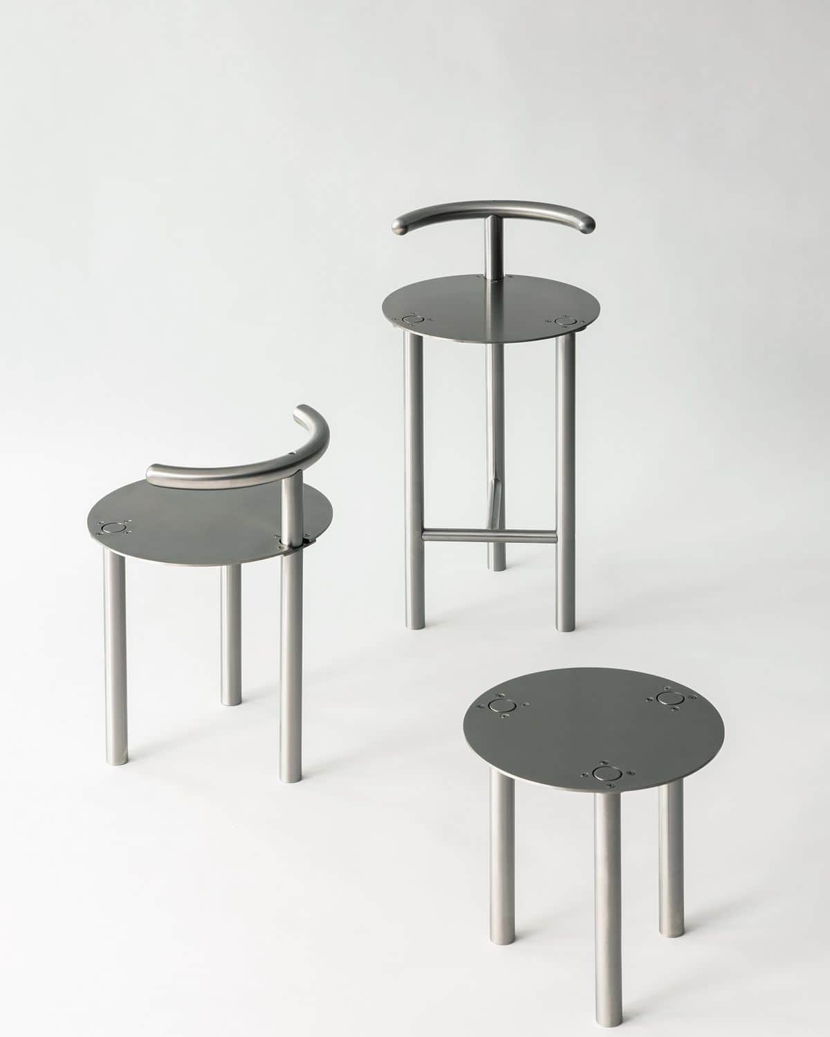 A modern bar stool with a circular seat, three cylindrical legs, and a curved backrest support. The… — 3D model