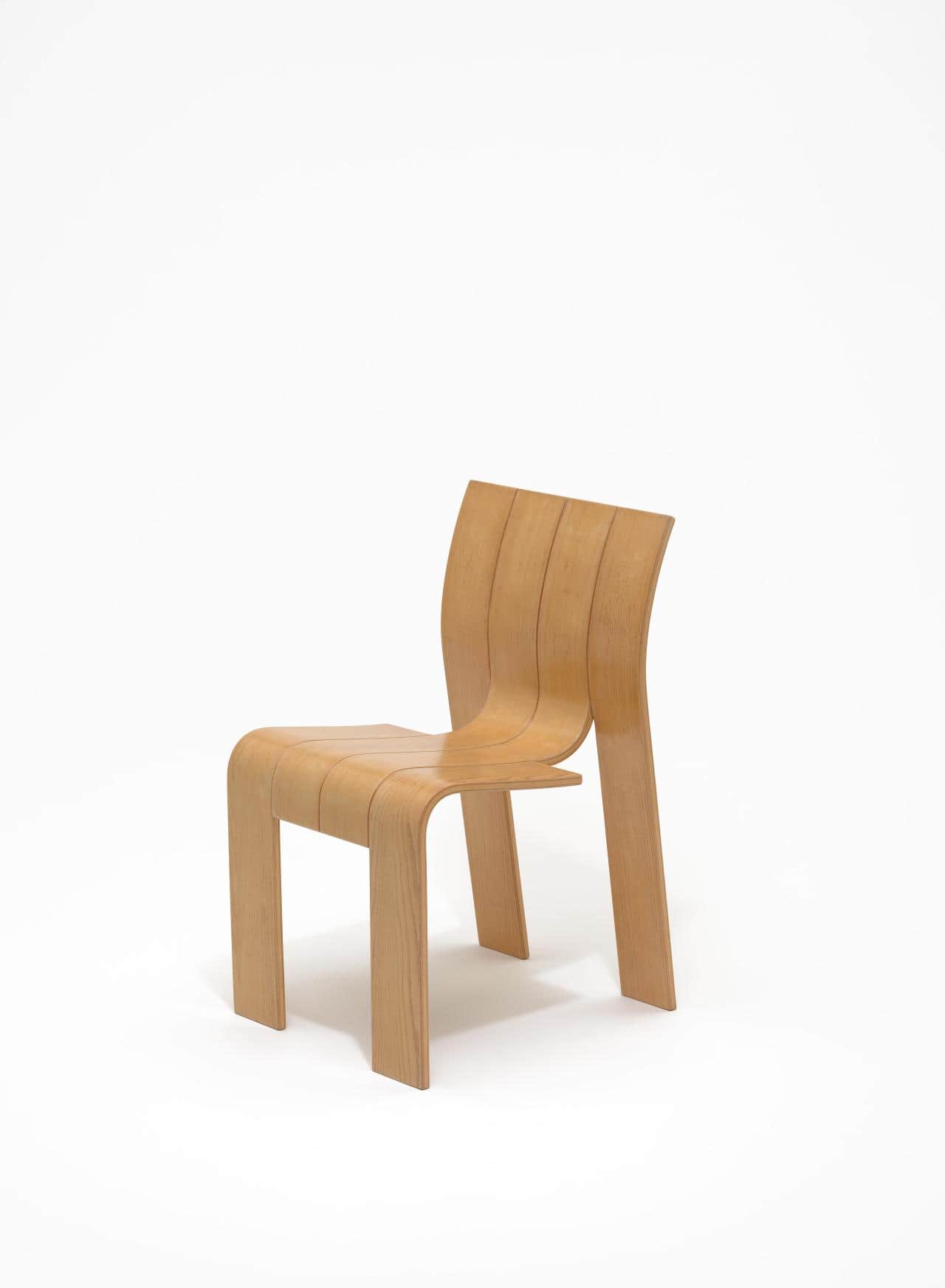 A modern, armless chair constructed from light-toned bent plywood, featuring a segmented, continuous… — 3D model
