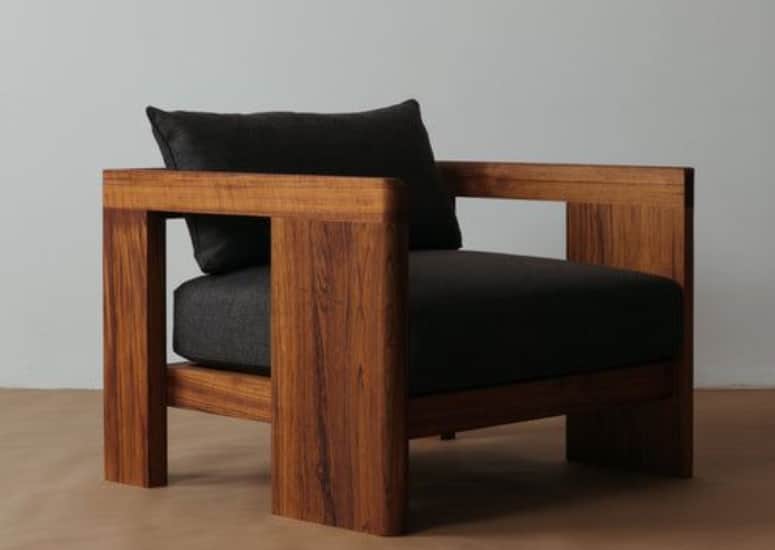 A modern armchair featuring a robust, open box-frame constructed from dark wood, likely walnut, comp… — 3D model