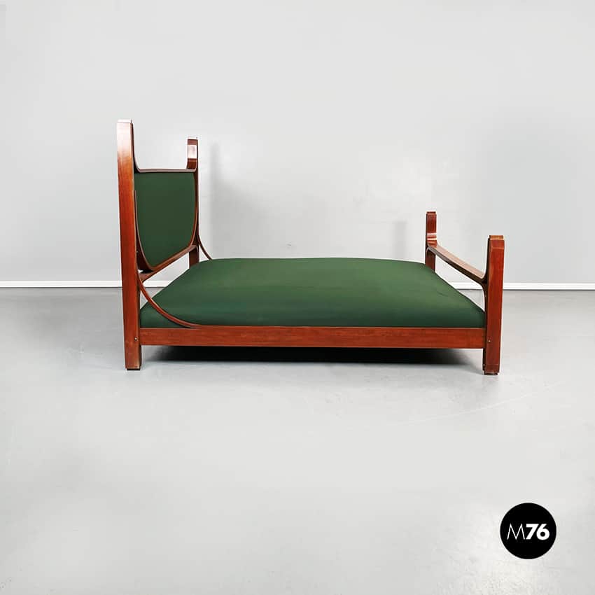 A daybed with a wooden frame and a green upholstered mattress. The frame has a rectangular base with… — 3D model