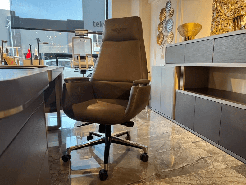A high-back executive office chair upholstered in brown leatherette, featuring integrated armrests w… — 3D model