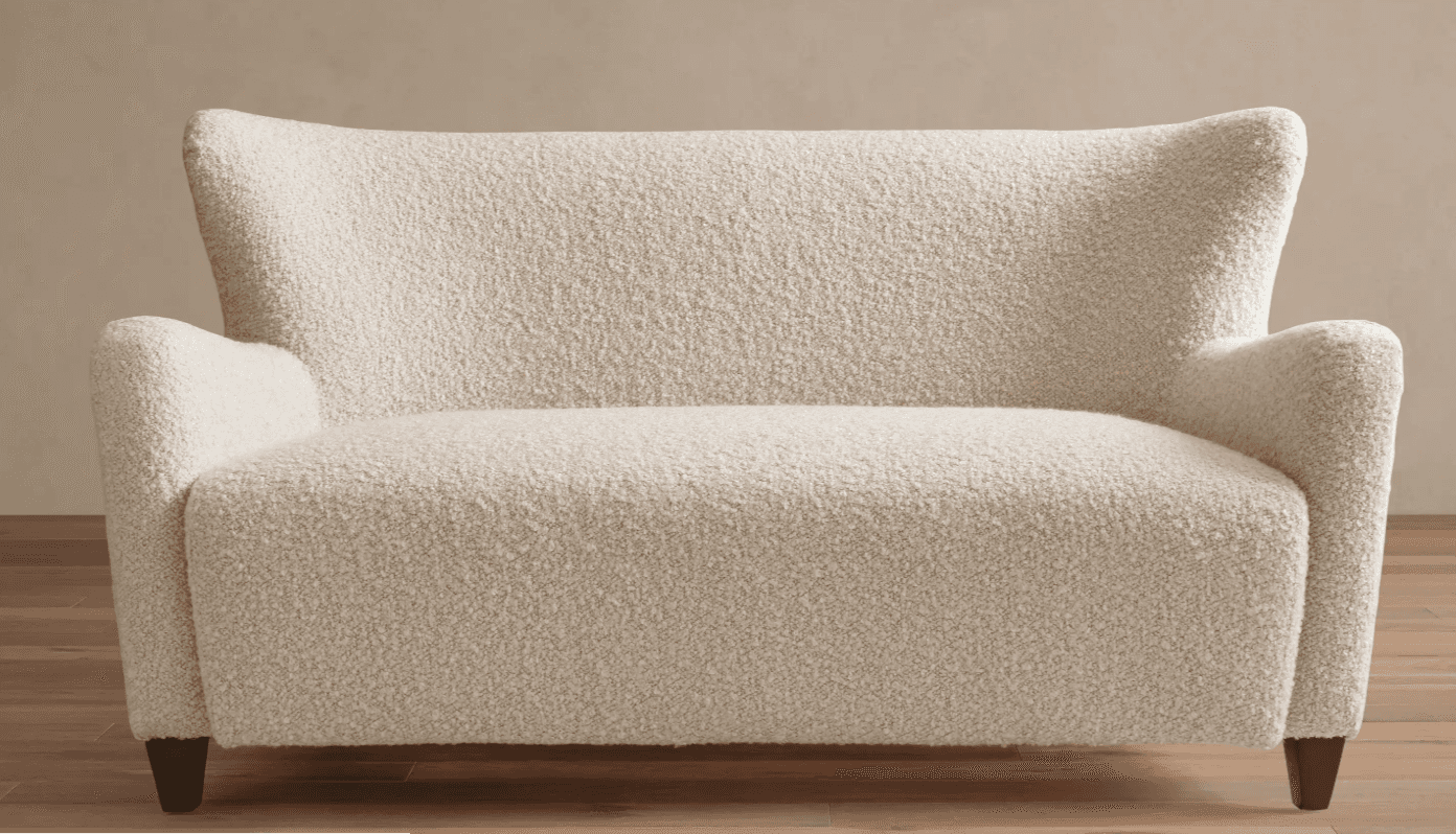 A contemporary two-seater loveseat upholstered in a cream-colored bouclé fabric. It features a high… — 3D model