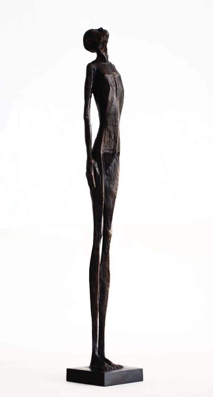 A tall, slender, abstract figurative sculpture depicting a human-like form with an elongated body an… — 3D model