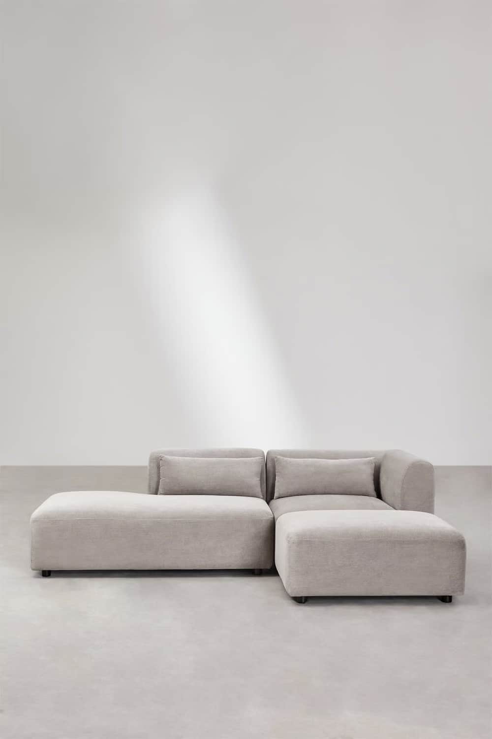 A contemporary sectional sofa with a chaise lounge extension and an ottoman. The sofa features plush… — free GLTF 3D model