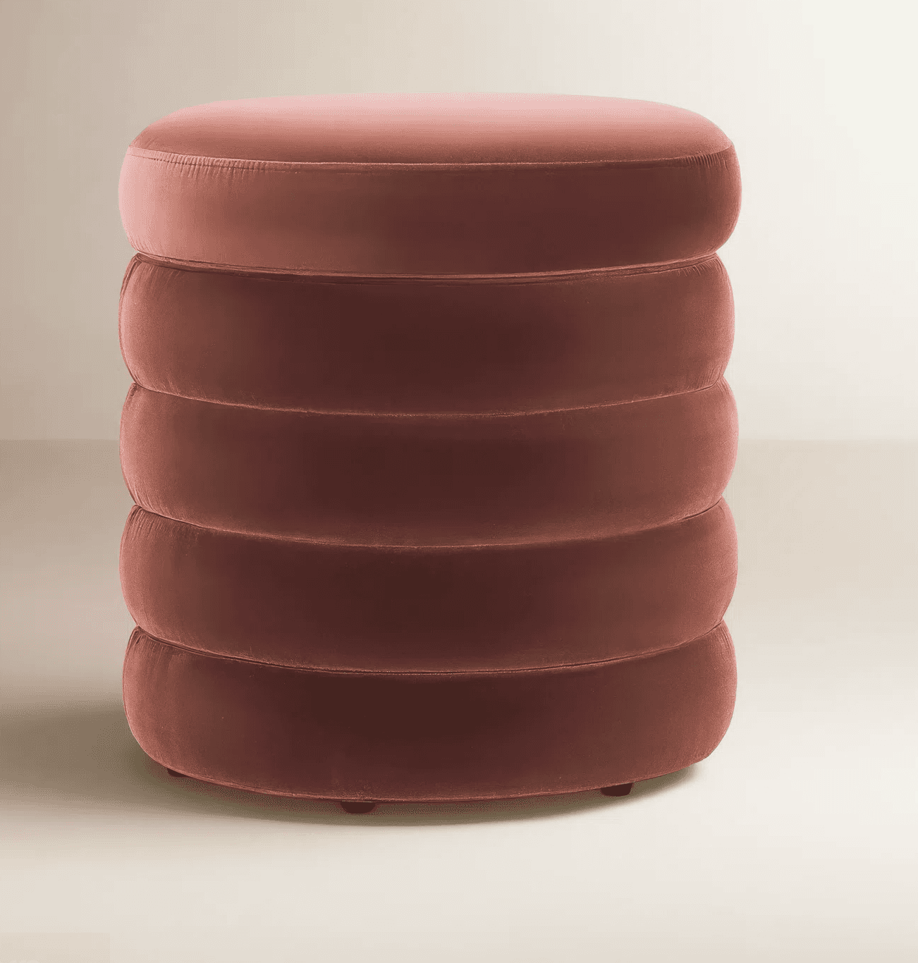 A cylindrical ottoman with a plush velvet upholstery. The body of the ottoman is segmented into five… — 3D model
