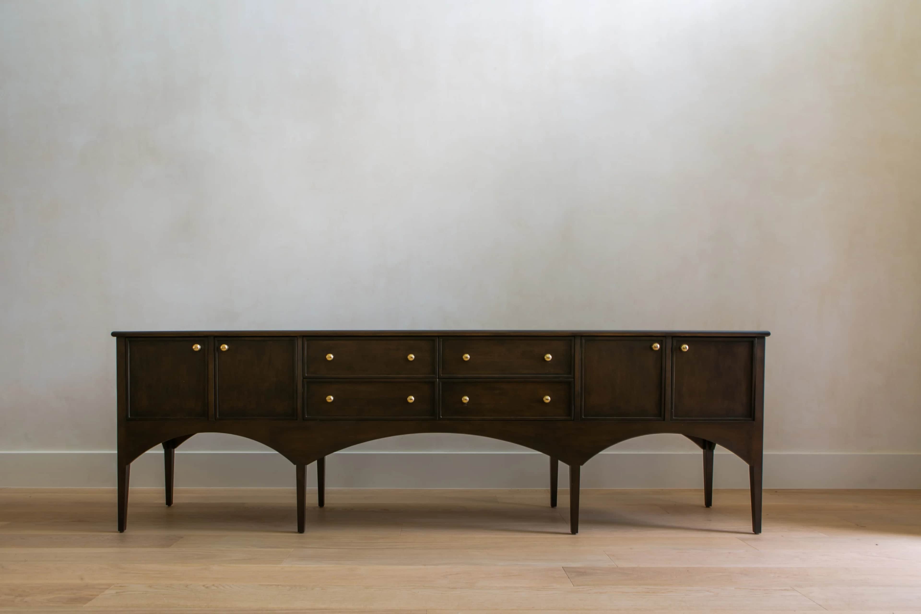 A long, low, dark-stained wooden sideboard featuring a central bank of six drawers flanked by two-do… — 3D model