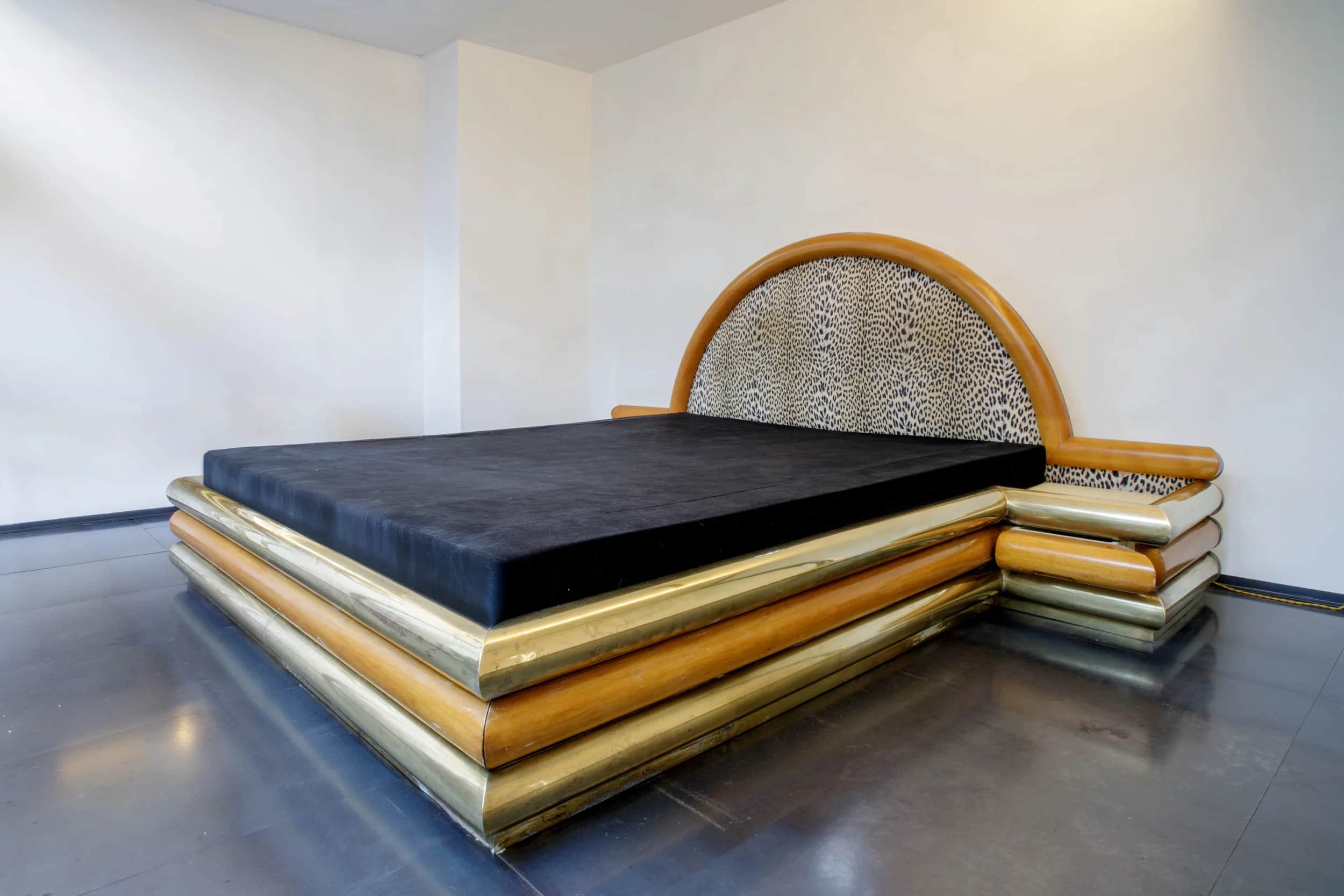 A bed frame with a distinctive design, featuring layered cylindrical elements in wood and brass arou… — free FBX 3D model