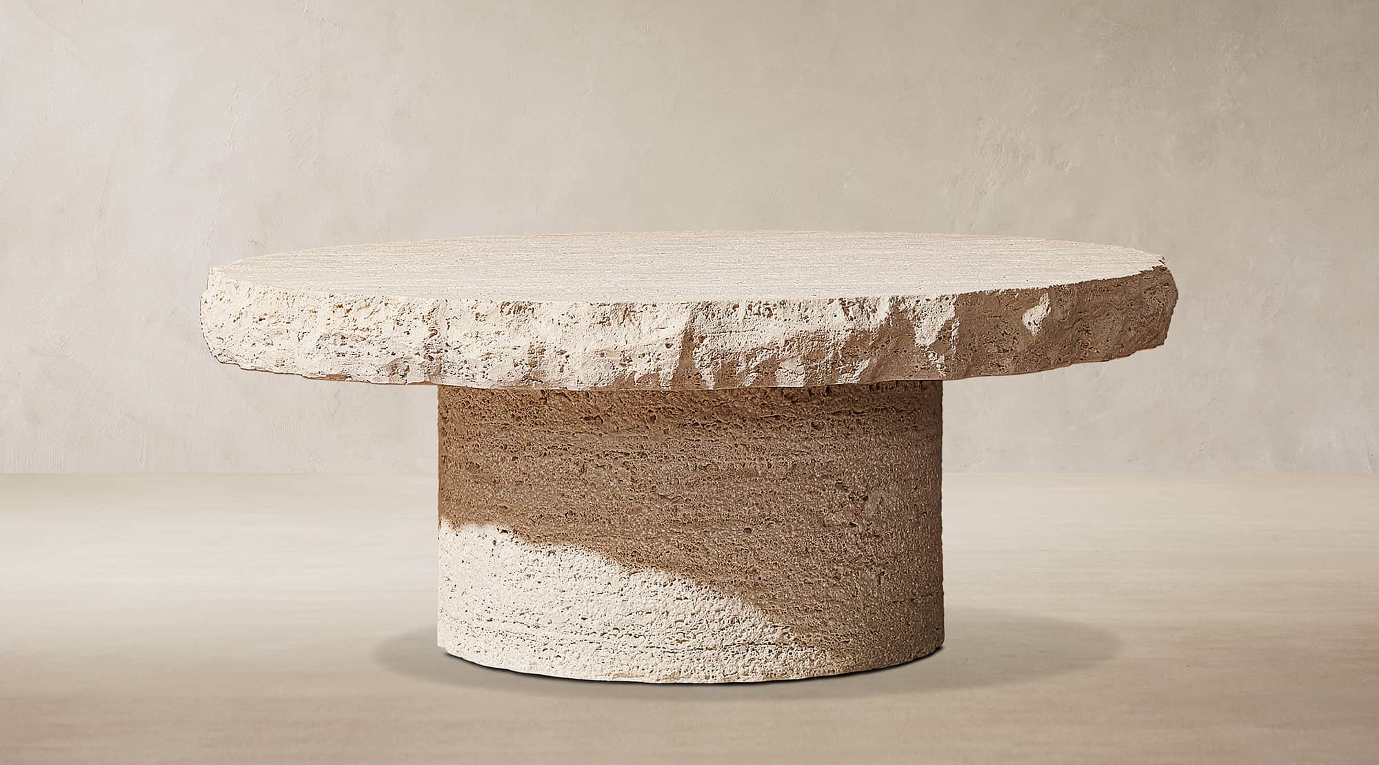 A contemporary round coffee table crafted entirely from rough-hewn travertine stone. The tabletop is… — 3D model