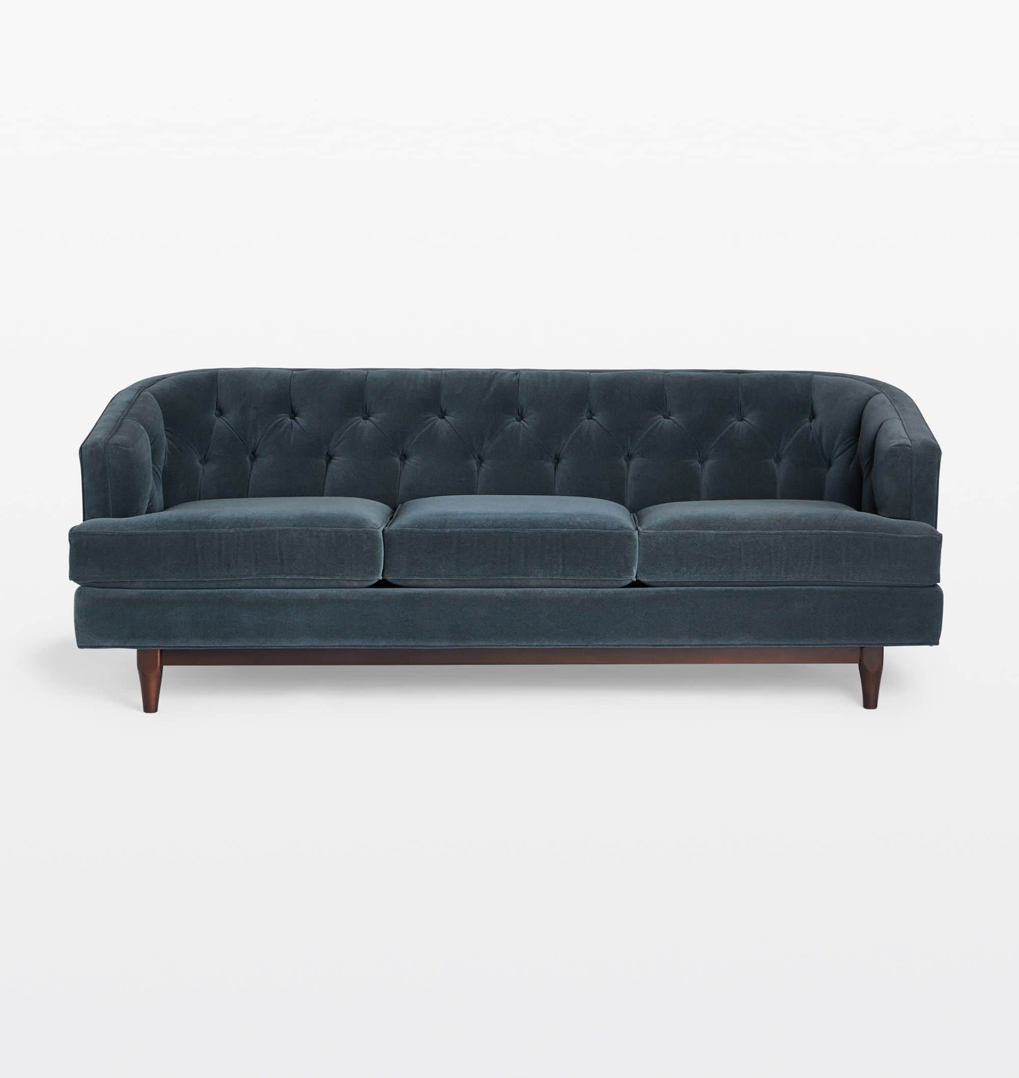 A three-seater sofa with a tufted back and seat cushions. The sofa features a rounded armrest profil… — 3D model