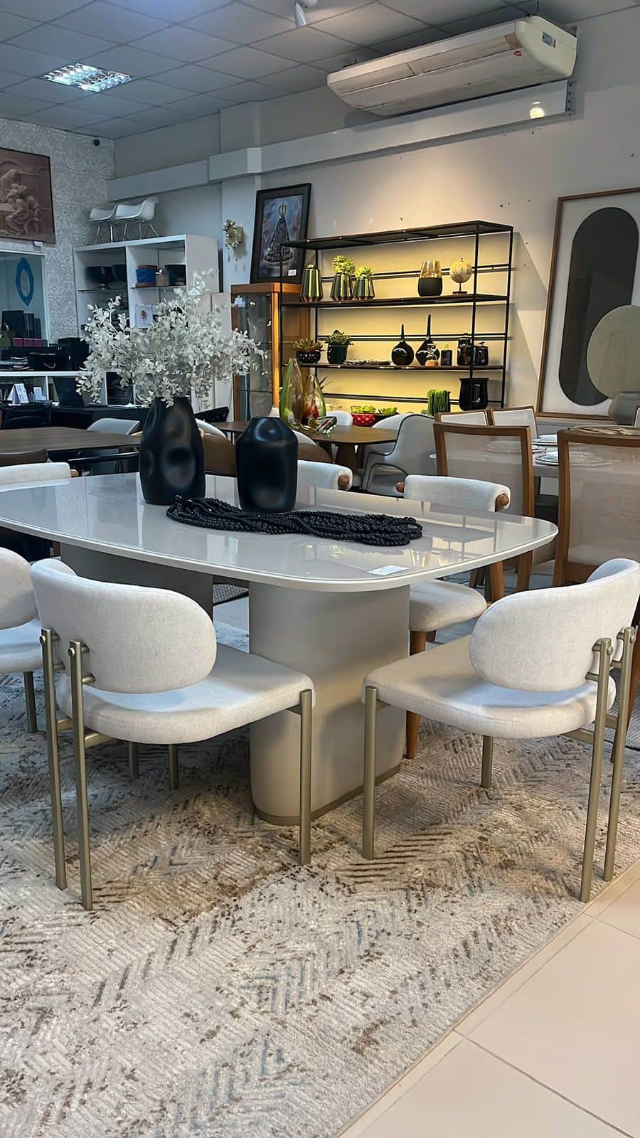 A contemporary dining table featuring a spacious, rounded rectangular top in a light, neutral tone,… — 3D model
