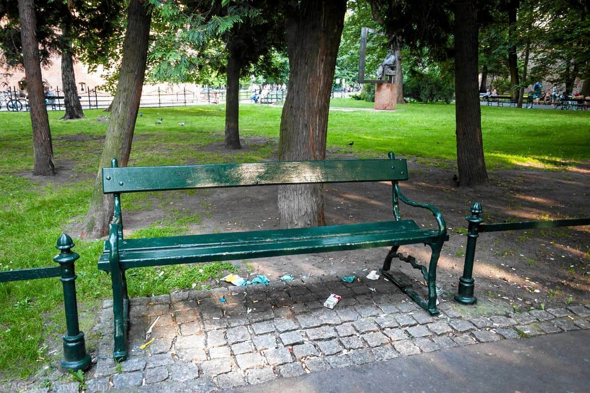 A traditional outdoor bench featuring a dark green finish, composed of parallel wooden slats for the… — 3D model