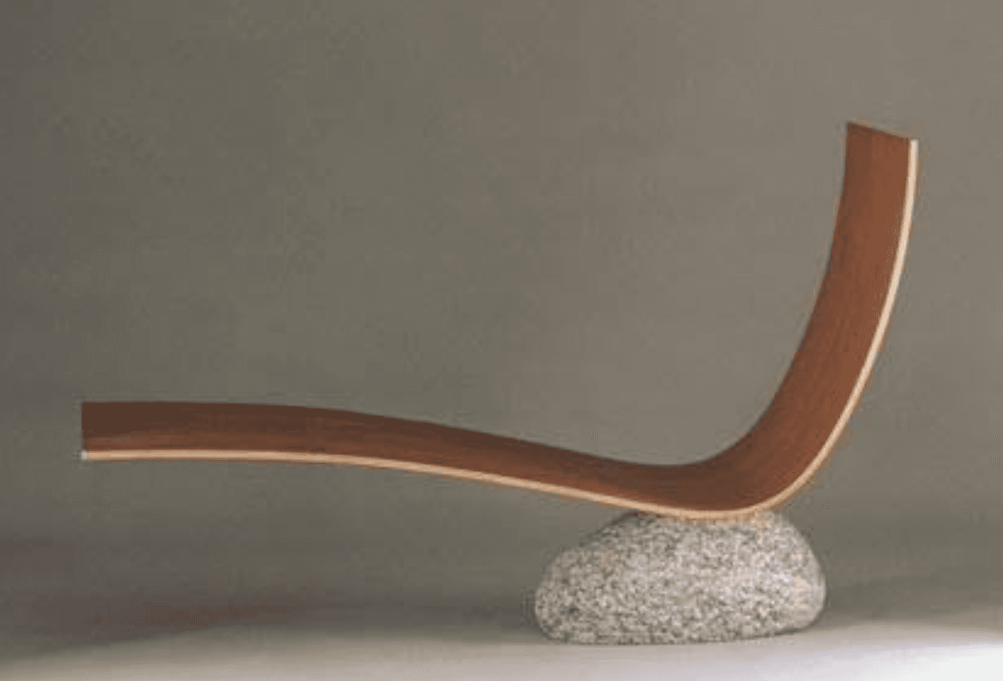 A modern sculptural chaise lounge featuring a gracefully curved, laminated wooden form supported by… — 3D model