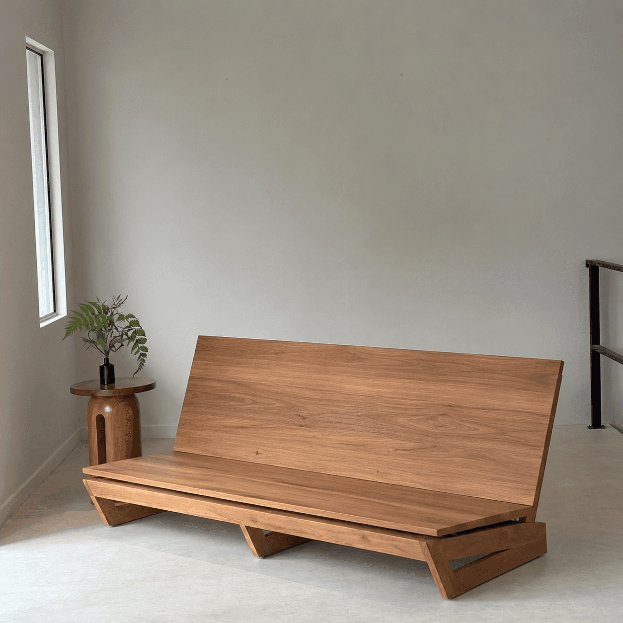 A modern, minimalist bench constructed from solid wood, featuring a long, flat seat and an angled ba… — 3D model