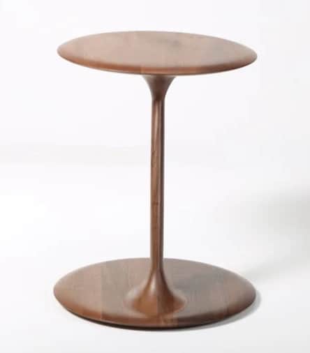 A minimalist pedestal side table crafted from dark wood, featuring a circular top and a flared, circ… — 3D model