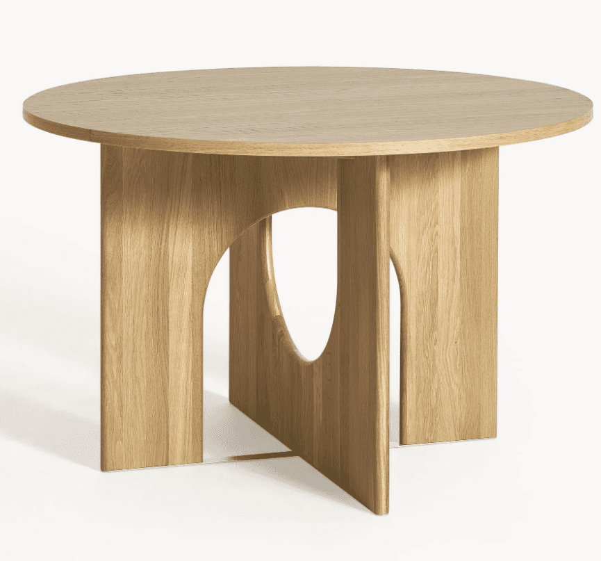 A round dining table features a smooth, circular tabletop crafted from light-toned wood with visible… — 3D model