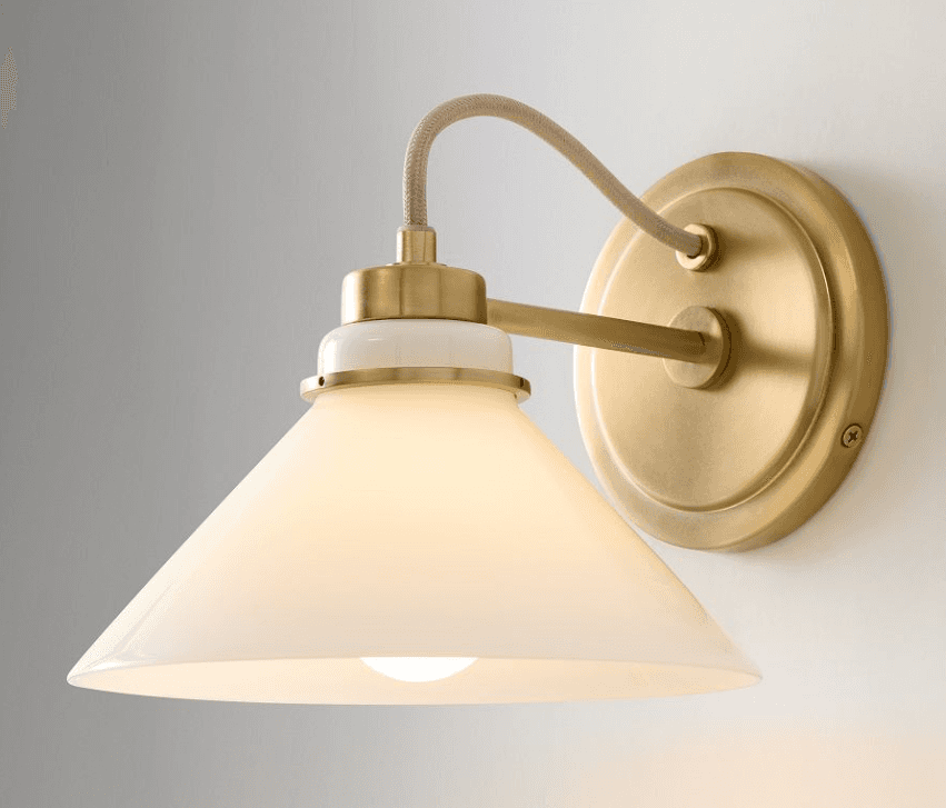 A contemporary wall sconce featuring a brushed brass finish on its mounting plate and arm. It has a… — 3D model