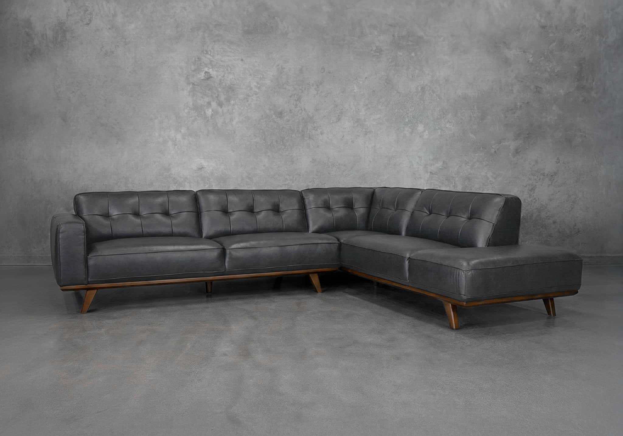 A dark grey sectional sofa with tufted back cushions and seating. The sofa has a low profile and is… — free SKP 3D model