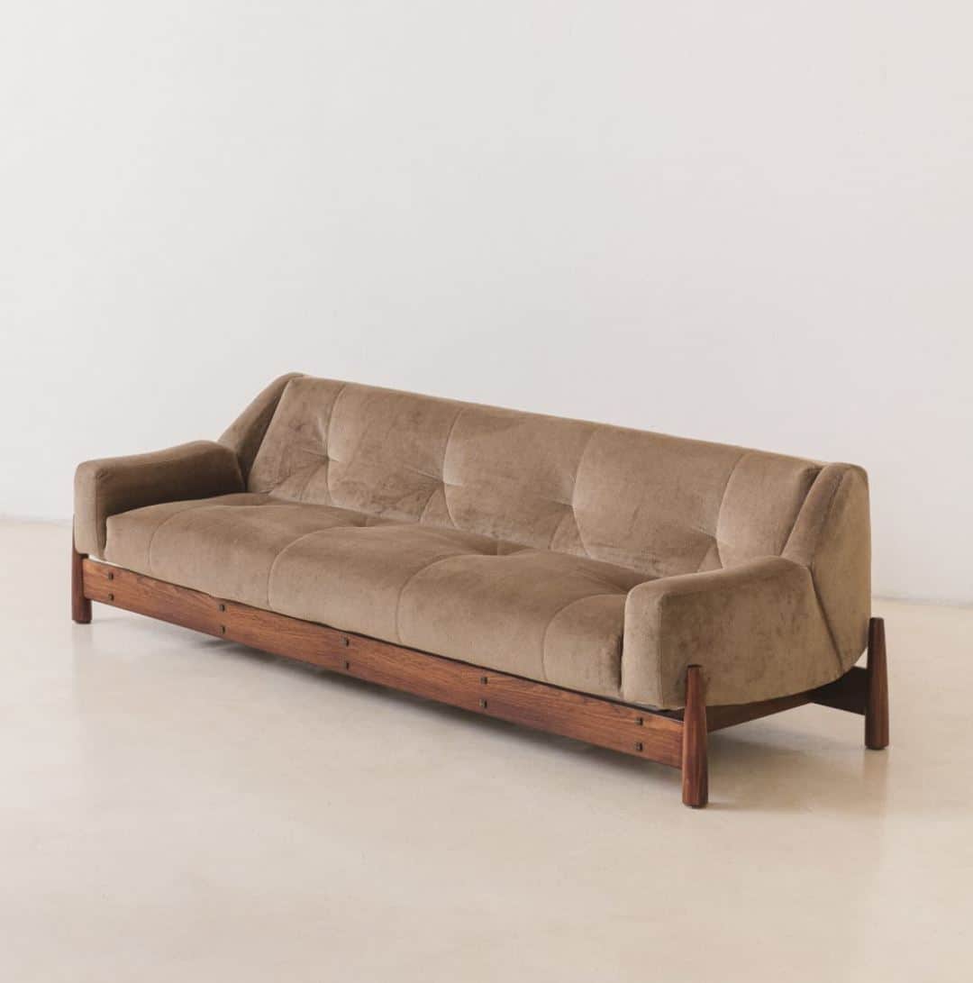 A mid-century modern style sofa with a tufted back and seat. It features a low-profile wooden base a… — free GLTF 3D model