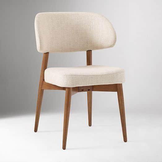 A modern upholstered chair with a curved backrest and four wooden legs. The seat and backrest are pa… — free GLTF 3D model