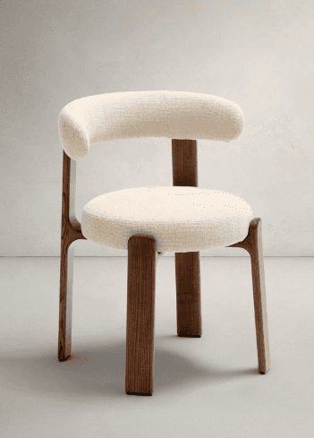 A modern upholstered armchair with a curved backrest and a circular seat. The frame and legs are con… — 3D model