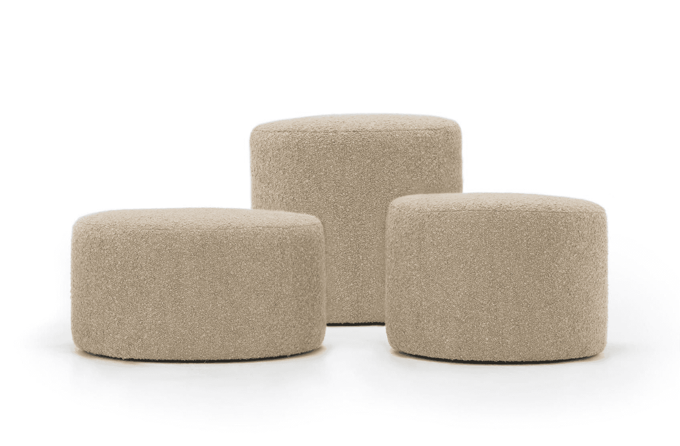 A set of three cylindrical ottomans, fully upholstered in a light beige or cream-colored boucle fabr… — 3D model