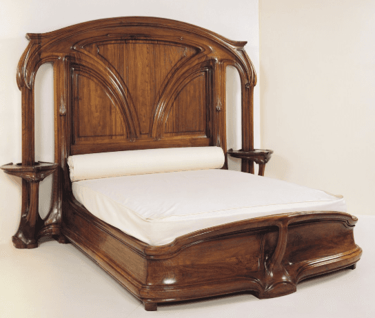 A large, ornate wooden bed frame with a high headboard featuring intricate carved detailing resembli… — free BLEND 3D model