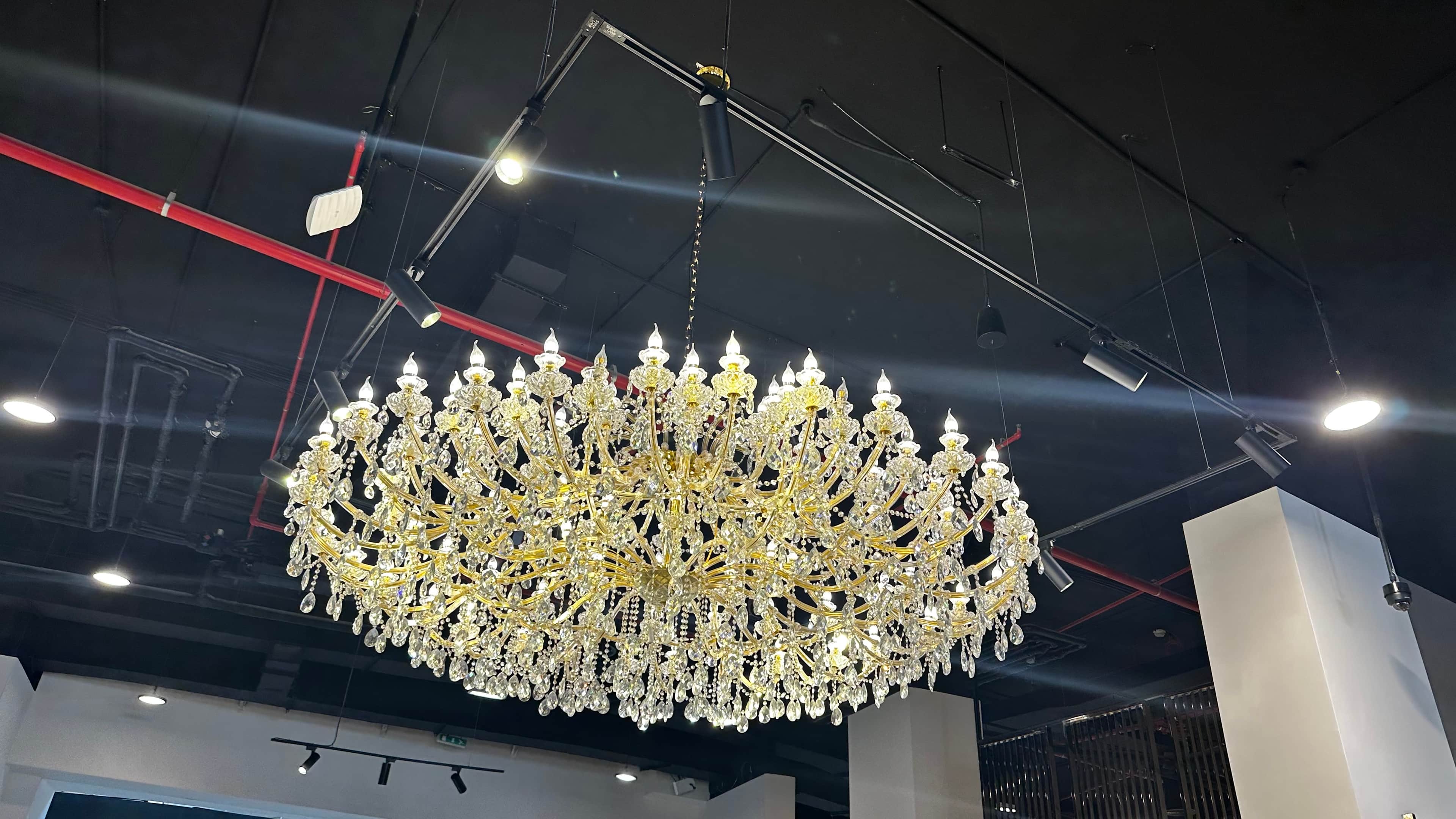 A large, multi-tiered chandelier with a gold-toned metal frame adorned with numerous clear crystal p… — free GLB 3D model