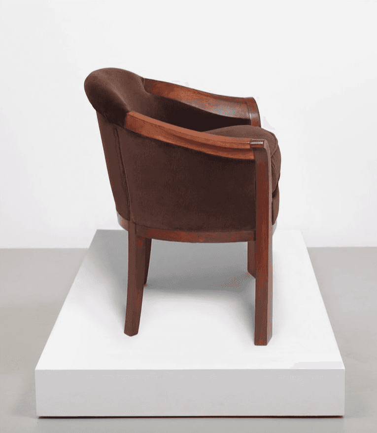 A dark brown upholstered armchair with a distinct Art Deco design, featuring a curved back, exposed… — free GLTF 3D model