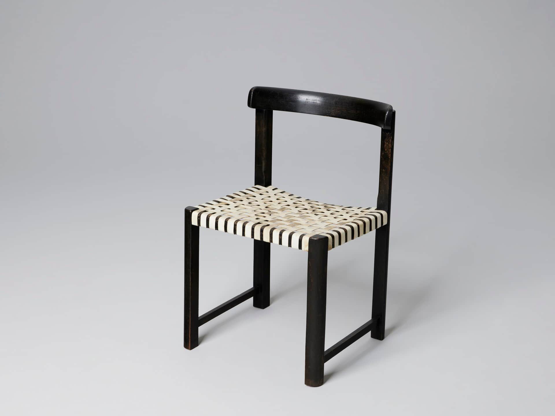 A dark-colored chair with a curved backrest and a woven seat. The frame appears to be constructed fr… — free FBX 3D model