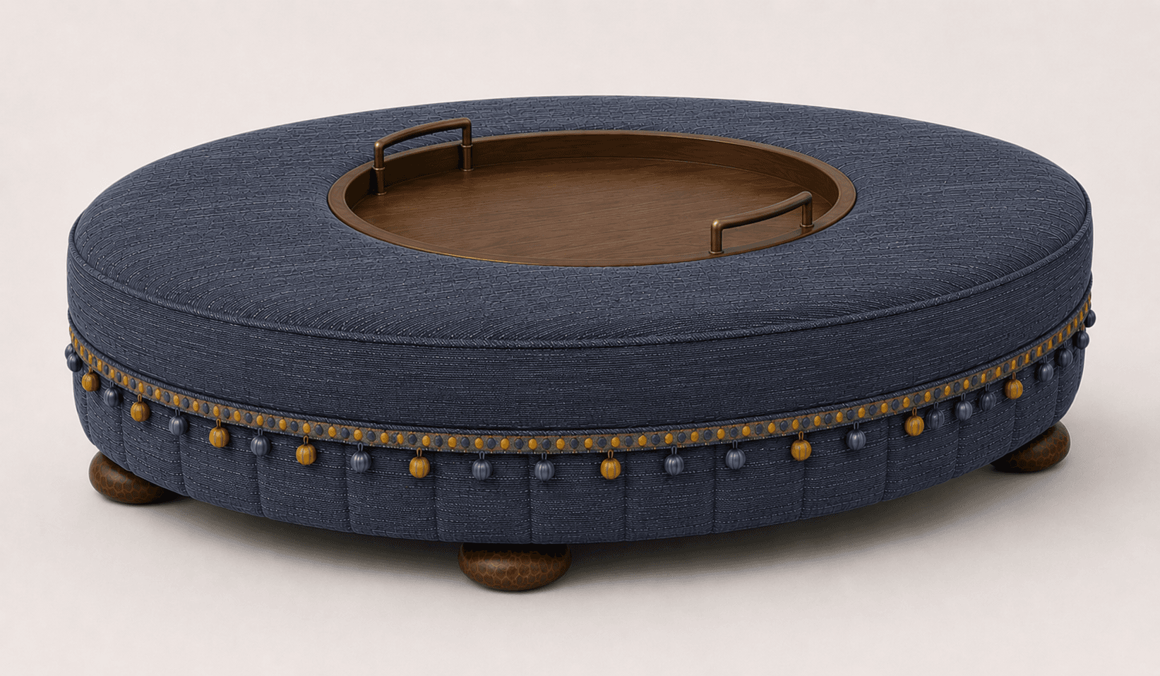 A round upholstered ottoman with a built-in wooden tray top. The ottoman is covered in a dark blue textured fabric and features decorative trim along the bottom edge with hanging tassels in blue and yellow. It stands on four short, carved wooden feet. — 3D model