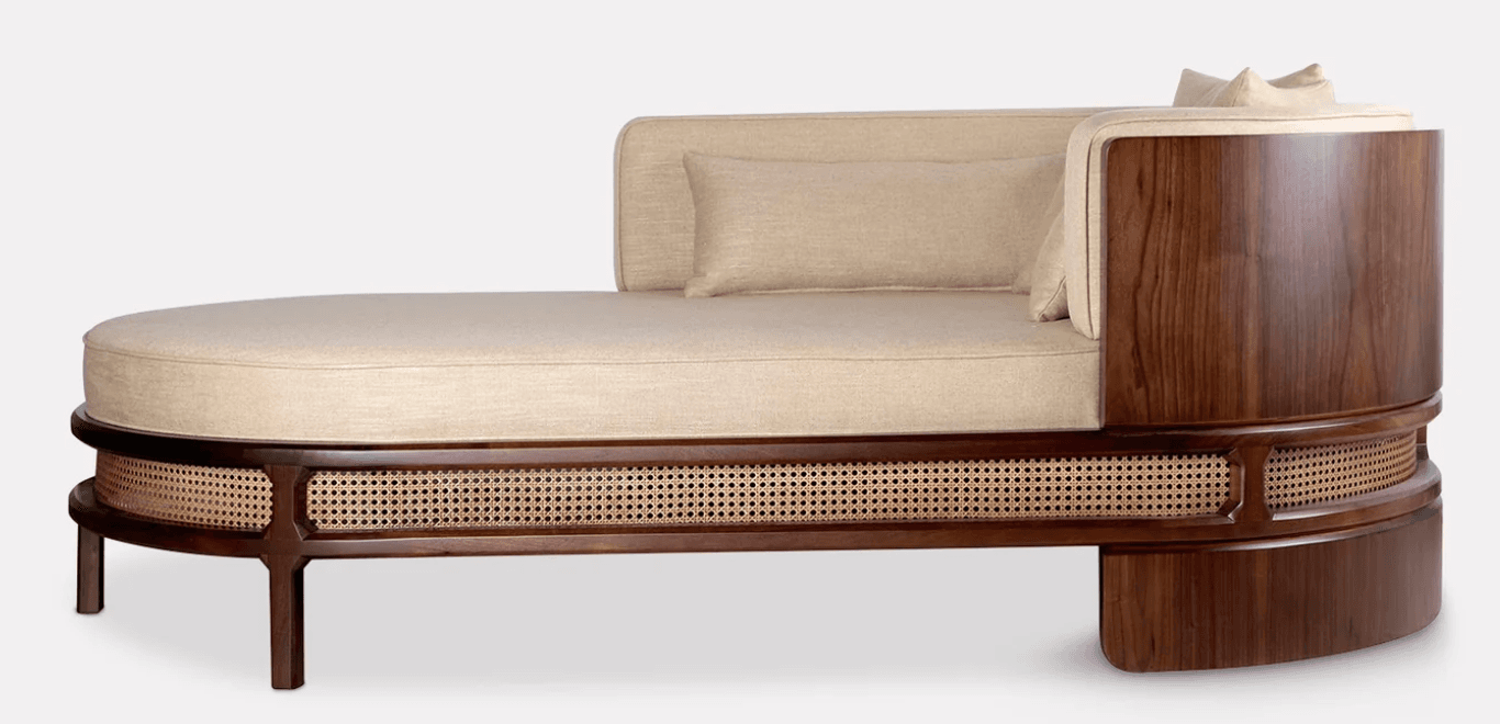 An elegant single-armed chaise lounge featuring a dark walnut wood frame with intricate cane webbing detail and plush upholstered cushions in a neutral beige fabric. — 3D model