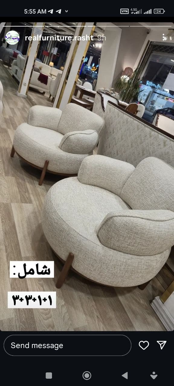 A modern, rounded accent chair upholstered in a light, neutral-toned fabric, featuring a continuous backrest and integrated armrests, supported by short, tapered wooden legs. — 3D model