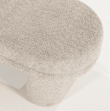 A modern, upholstered bench with a textured boucle fabric. The bench has a low profile and features two cylindrical legs that support a rectangular, elongated seat. The overall design is minimalist and contemporary, with rounded edges. — 3D model