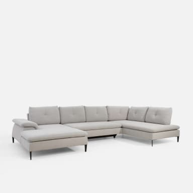 A U-shaped sectional sofa with light grey fabric upholstery. The sofa features tufted back cushions and a chaise lounge on one end and a rounded armrest on the other. It is supported by dark, tapered legs. — 3D model