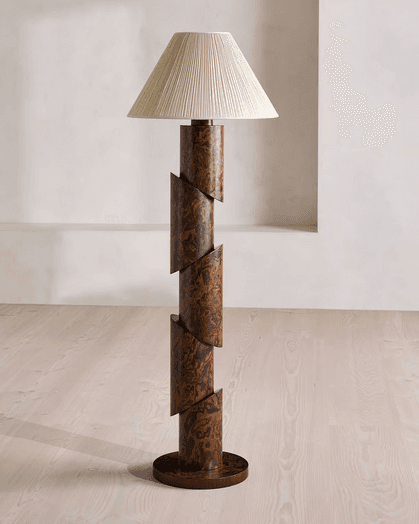 A modernist floor lamp featuring a segmented, cylindrical column base with a burl wood-like pattern, topped with a conical, pleated fabric shade. The base is composed of several cylindrical sections that appear to be cut diagonally and offset, creating a dynamic, spiraling effect. — 3D model