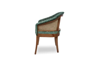 An upholstered armchair featuring a barrel-shaped back and integrated armrests, covered in a dark green velvet fabric with a textured, mottled pattern. The chair is supported by four solid wooden legs that are slightly tapered. — 3D model