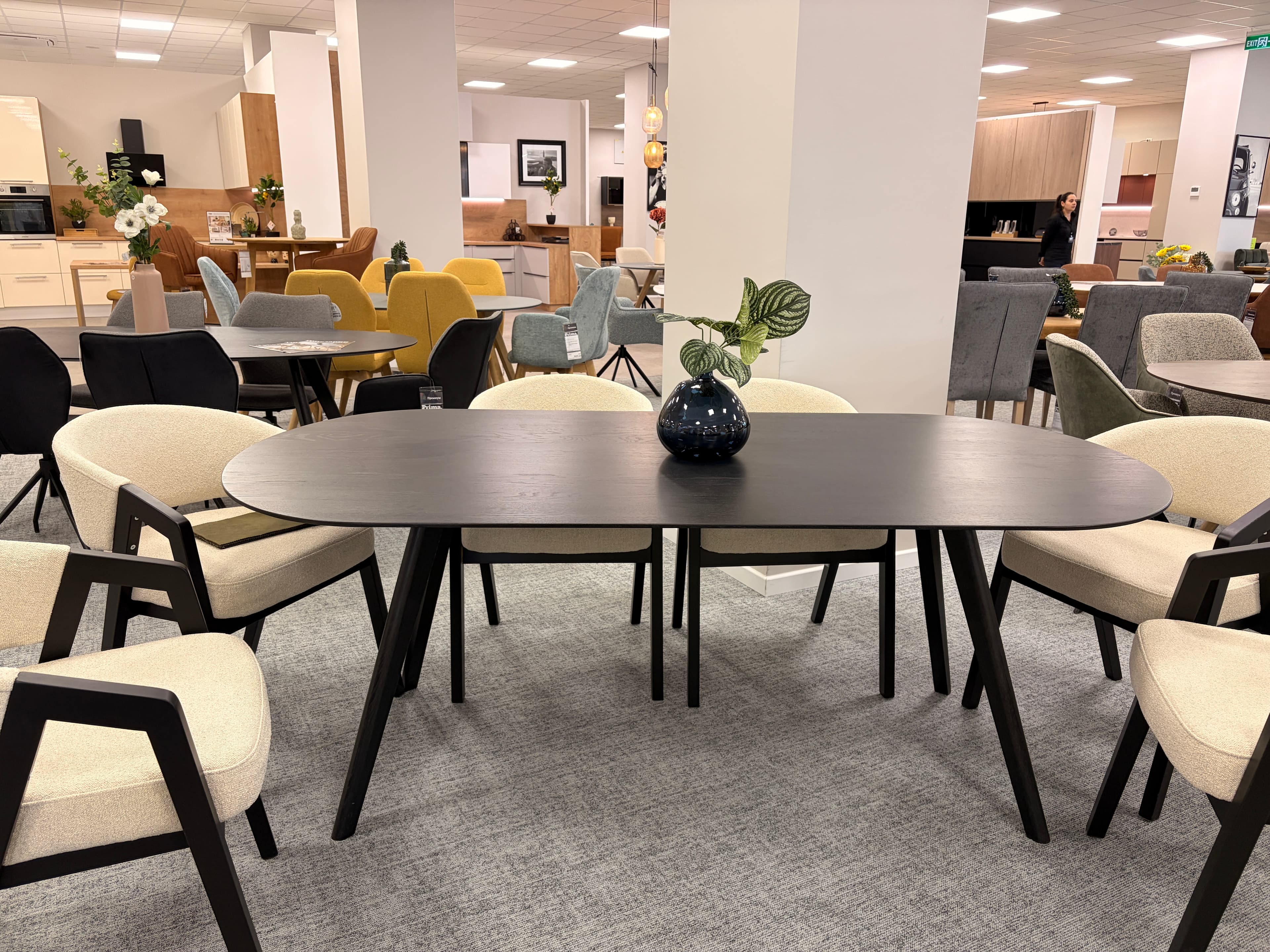 A dark-colored, oval-shaped coffee table with four tapered legs. The surface appears to be smooth and matte. — 3D model