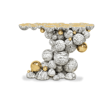 An avant-garde console table featuring a sculptural base composed of numerous white spheres and half-spheres with a cracked, black vein marble-effect pattern, interspersed with polished gold spheres of varying sizes. The table's top surface is formed by a series of half-spheres with flat, gold-colored tops, creating a segmented, irregular tabletop. The overall design presents a striking, artistic aesthetic. — 3D model