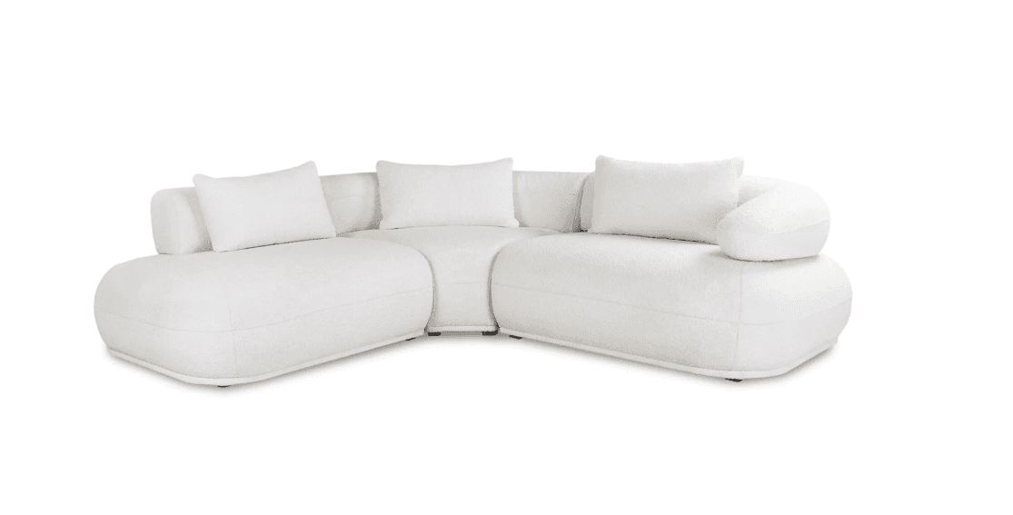 A white L-shaped modular sectional sofa with soft, rounded forms and plush boucle upholstery, featuring a low profile and loose back cushions. — 3D model