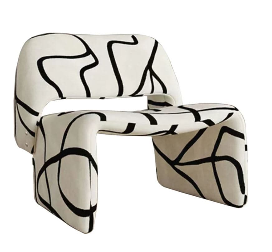 An armchair with a distinctive, sculptural form. The chair features a unified, molded structure that forms both the seat, back, and armrests, with a cutout in the front of the seat area. The upholstery is a light color with a bold, irregular black line pattern distributed across its surface. The base is integrated into the overall design, appearing as a continuation of the chair's structure. — 3D model