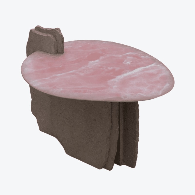 An abstract coffee table with an oval, pink marble or stone top supported by two rough, irregular-shaped stone or concrete bases. The top features white veining against a soft pink background. The bases are grey-brown and appear to be constructed from stacked, rough-hewn slabs. — 3D model