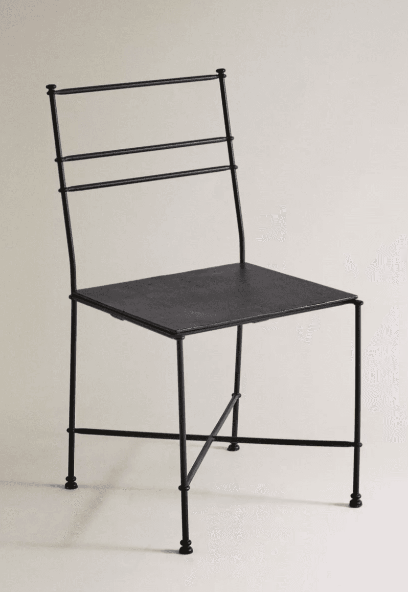 A minimalist side chair constructed from black metal. The seat is a flat, rectangular surface. The backrest is composed of two vertical supports connected by three horizontal bars. The chair has four slender legs, with decorative spherical finials at the base of each leg. The legs are connected by crossbars for added stability. — 3D model
