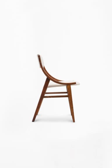 A modern armchair featuring a wooden frame and upholstered seat and backrest. The frame has a curved, organic design for the armrests and back supports, while the legs are straight and tapered. The upholstery is a neutral grey fabric. — 3D model