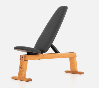 An adjustable weight bench with a solid light wooden frame and black upholstered pads. The bench features a main seating pad and a backrest that appears to be adjustable to various incline positions, supported by a black metal mechanism. The wooden frame has a clean, minimalist design with a broad, stable H-shaped base at each end. — 3D model
