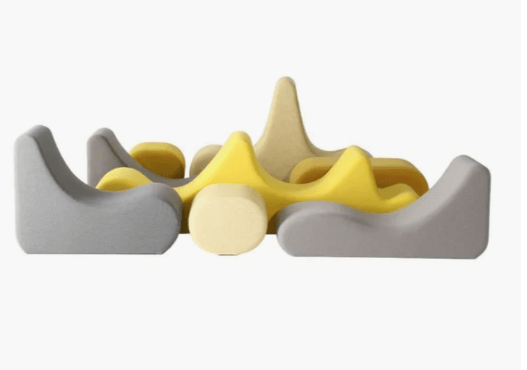 A modular soft play set composed of multiple distinct, upholstered foam pieces in yellow, beige, and gray, designed to be arranged into various seating or play configurations. — 3D model