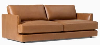 A contemporary two-seat loveseat upholstered in a warm, cognac-colored leather. It features a streamlined, low-profile design with plump, removable seat and back cushions. The armrests are subtly integrated, appearing as low, rounded track arms. The base is simple and rests on discreet, short feet, giving it a minimalist aesthetic. — 3D model