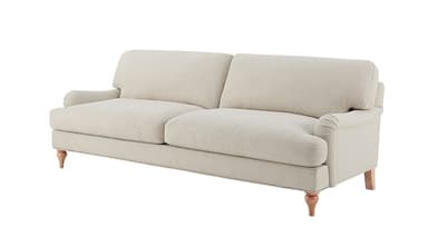 A side profile of a light-colored sofa with a textured fabric upholstery. The sofa features plush back cushions and armrests, and is supported by four turned wooden legs. The stitching detail is visible along the seams of the upholstery. — 3D model