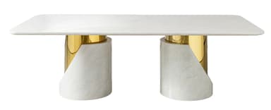 A contemporary rectangular dining table featuring a white marble tabletop and two distinctive pedestal bases. Each base is cylindrical, constructed from white marble with a prominent, curved cut-out revealing a polished brass inner cylinder. The design emphasizes a luxurious material contrast between the cool marble and warm metallic brass. — 3D model